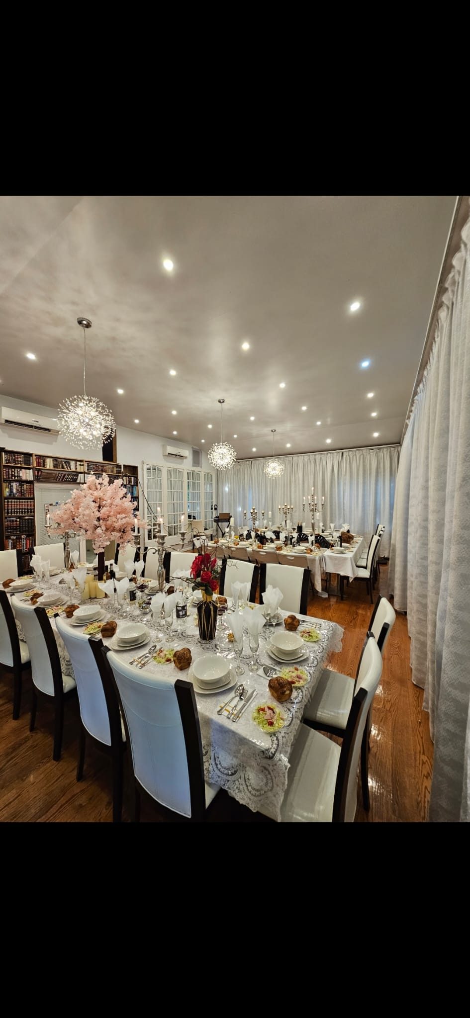 Banquet hall with recessed ceiling downlights above floral-set dining tables