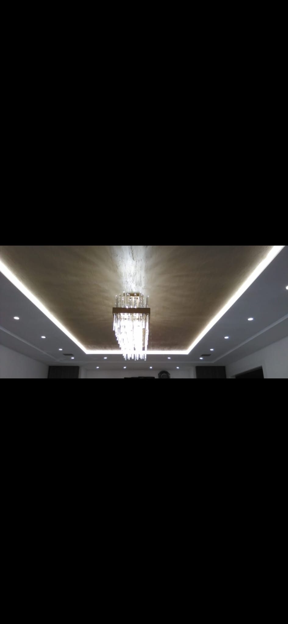 Recessed ceiling cove with concealed LED lighting framing a central chandelier