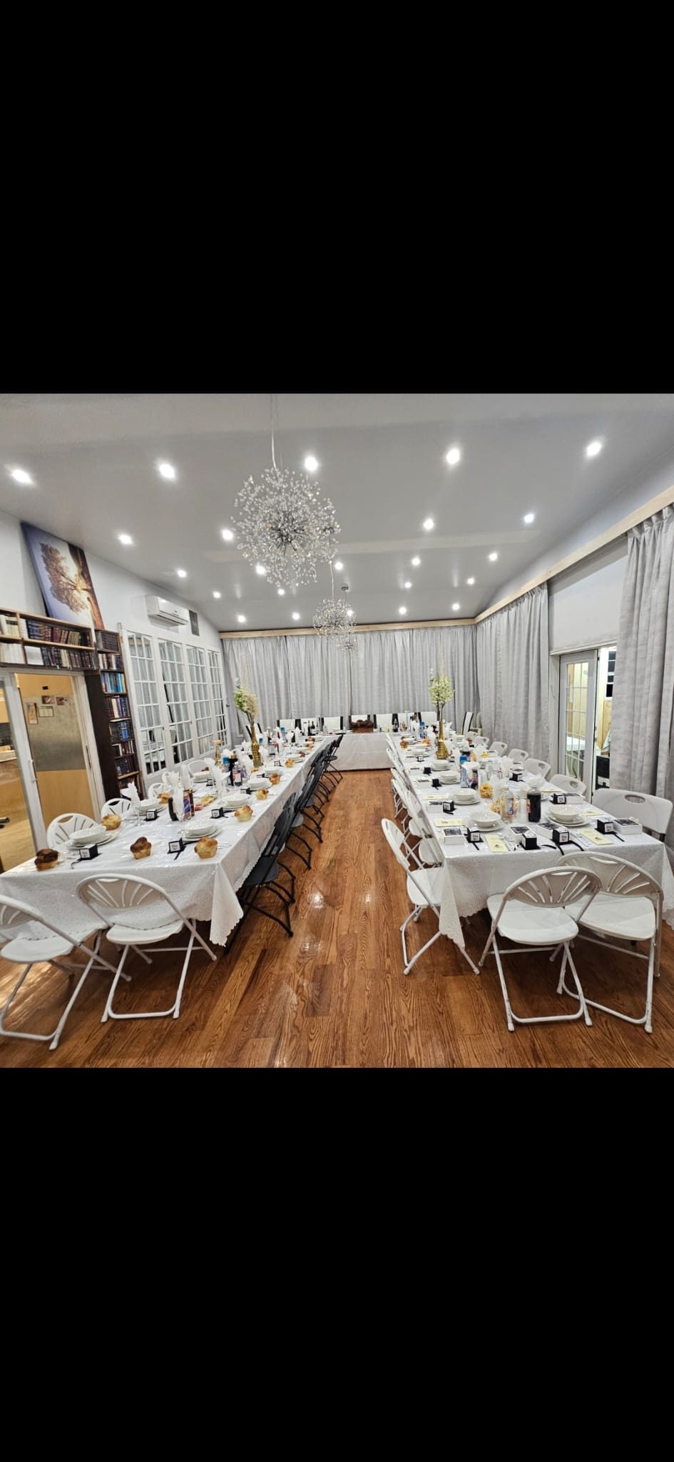 Event room with chandeliers and recessed downlights above set banquet tables