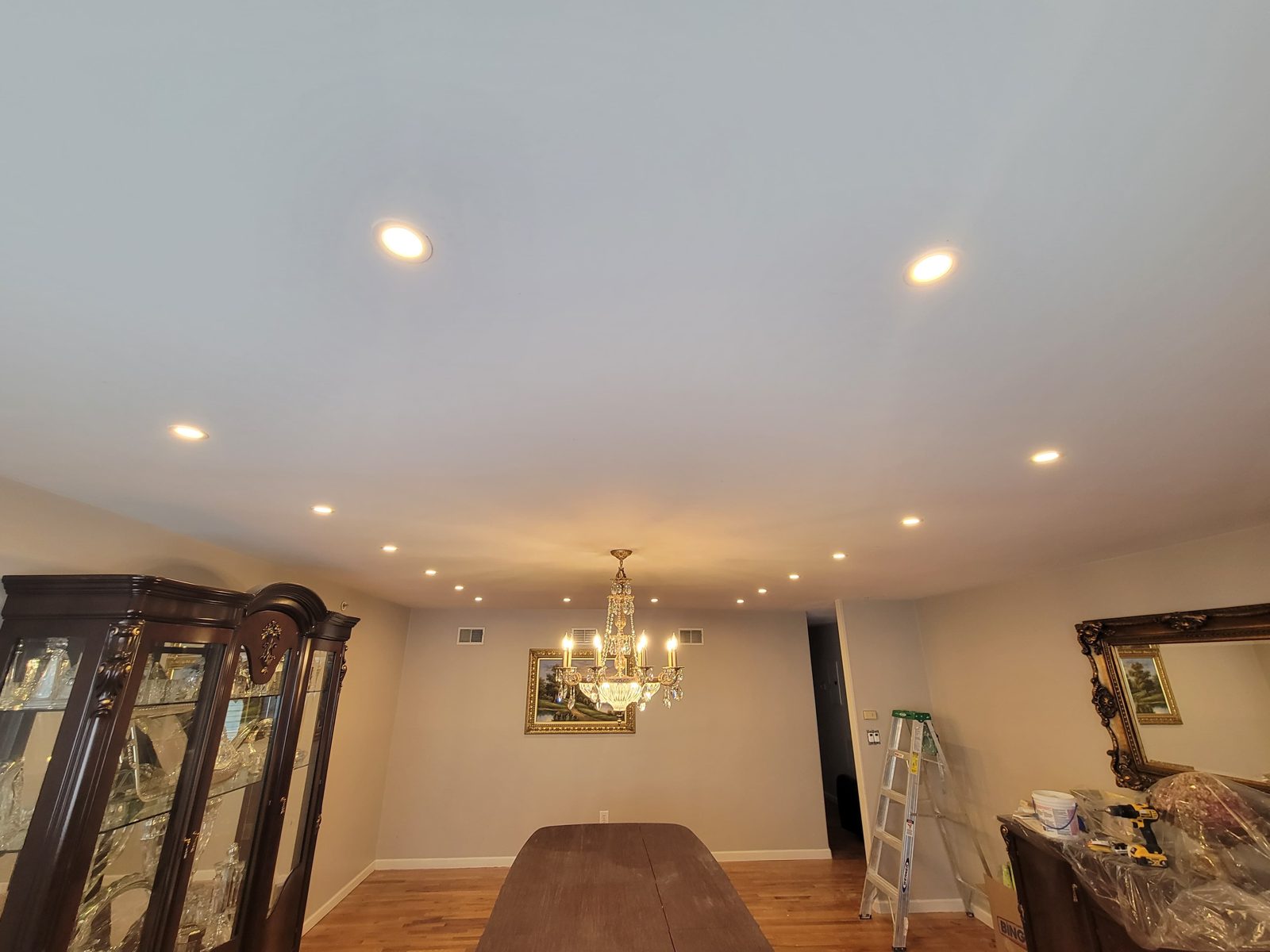 Warm room with a small chandelier and recessed perimeter downlights