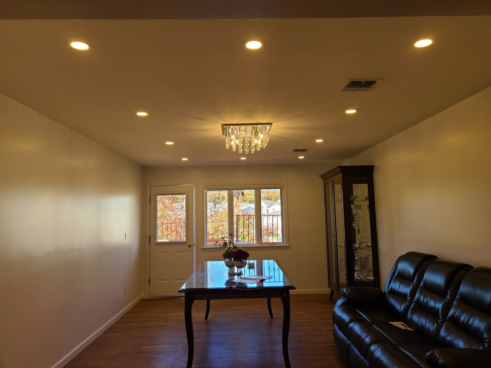 Lounge with leather seating, a chandelier, and recessed ceiling downlights
