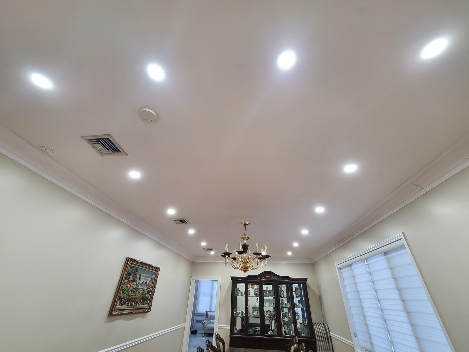 Dining room with a chandelier and surrounding recessed downlights