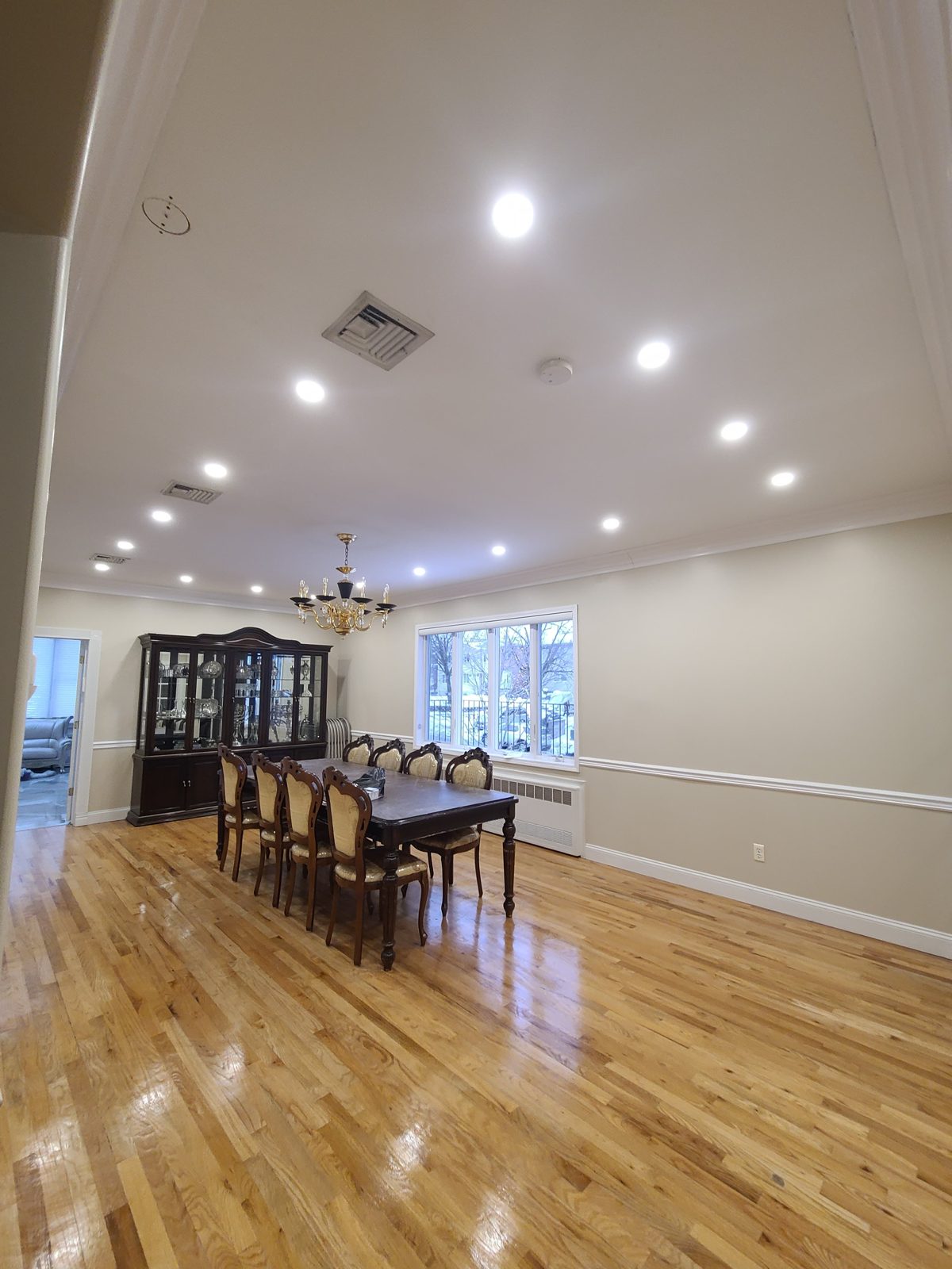 Dining area with hardwood floors and recessed downlights near tall windows