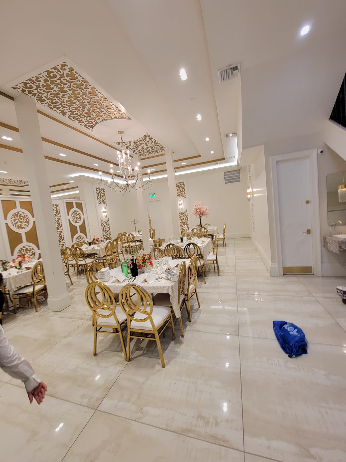 Formal dining hall with gold chairs beneath a patterned illuminated ceiling