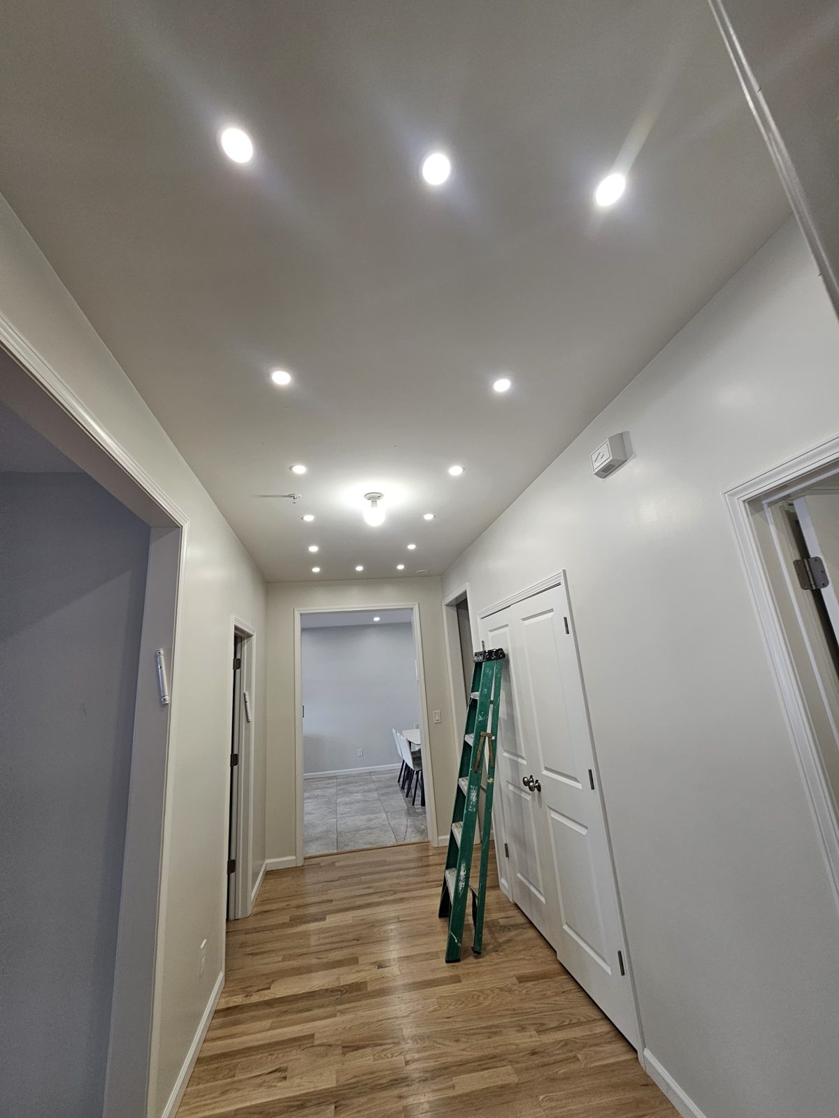 Corridor with recessed downlights leading to a bright doorway