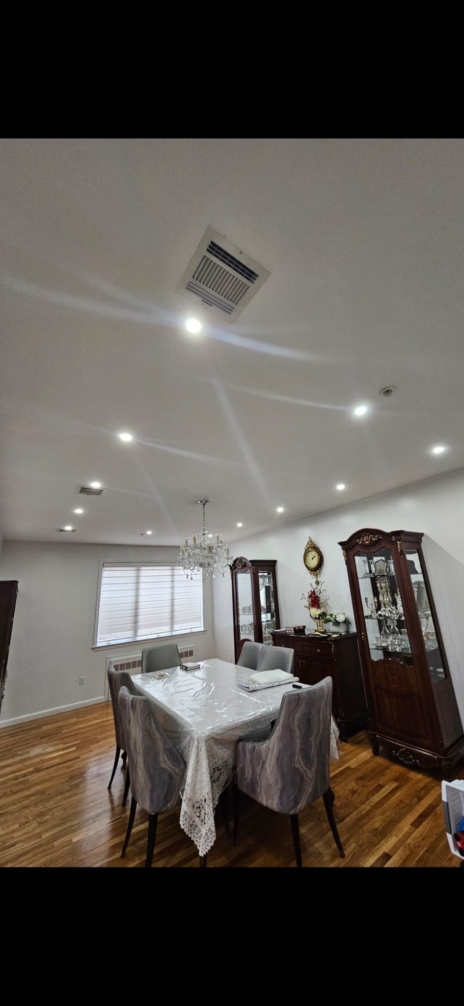 Dining room with a set table, display cabinet, and recessed ceiling downlights