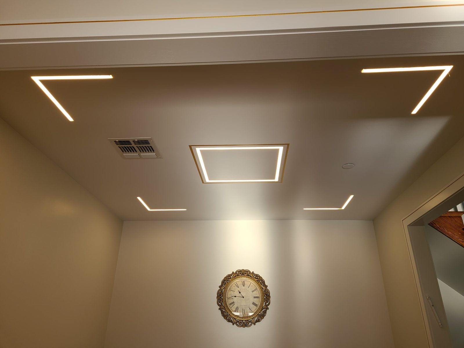Ceiling with angled linear LED light lines forming a geometric frame