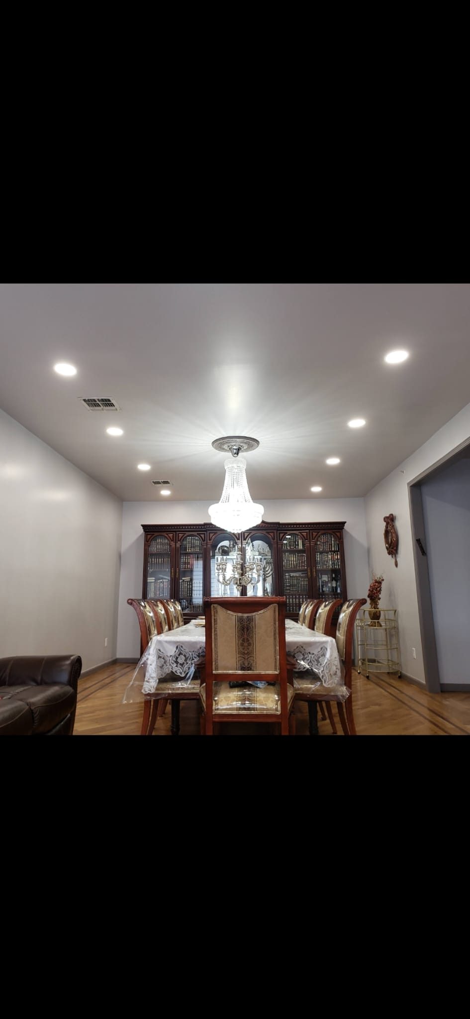 Dining room with a pendant chandelier above the table and recessed downlights