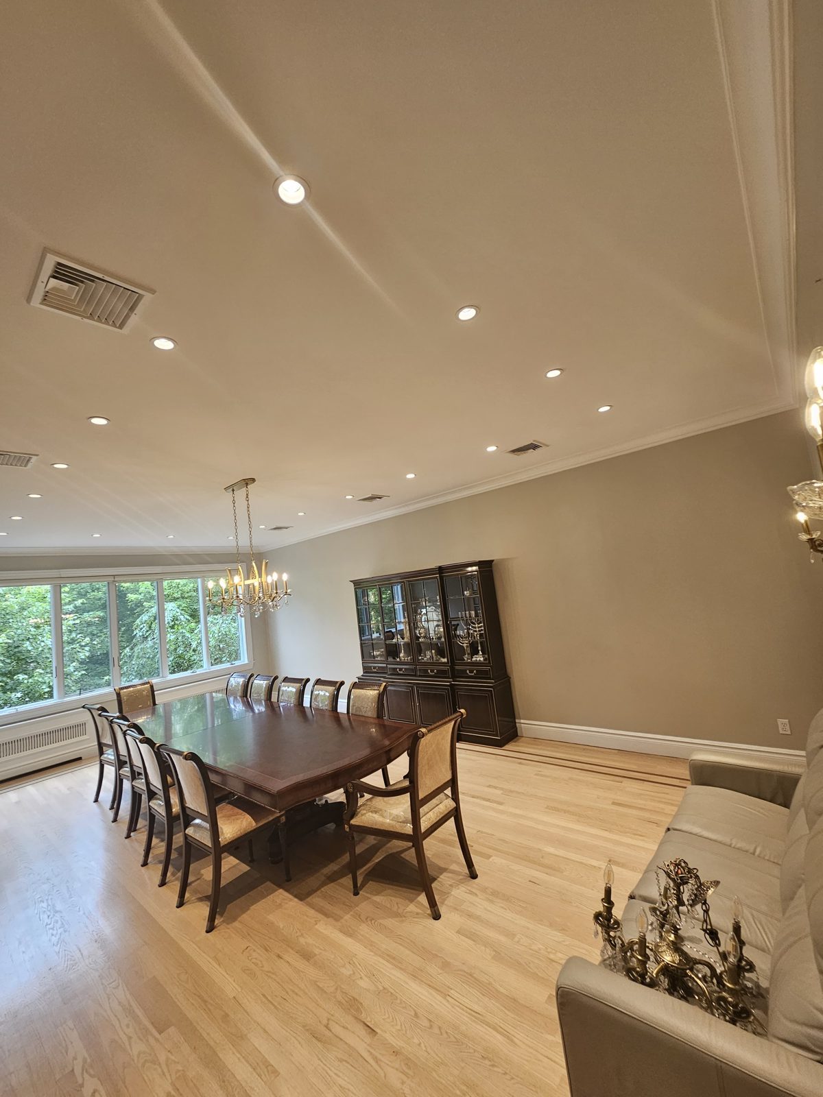 Dining table beside a display cabinet under recessed ceiling lighting