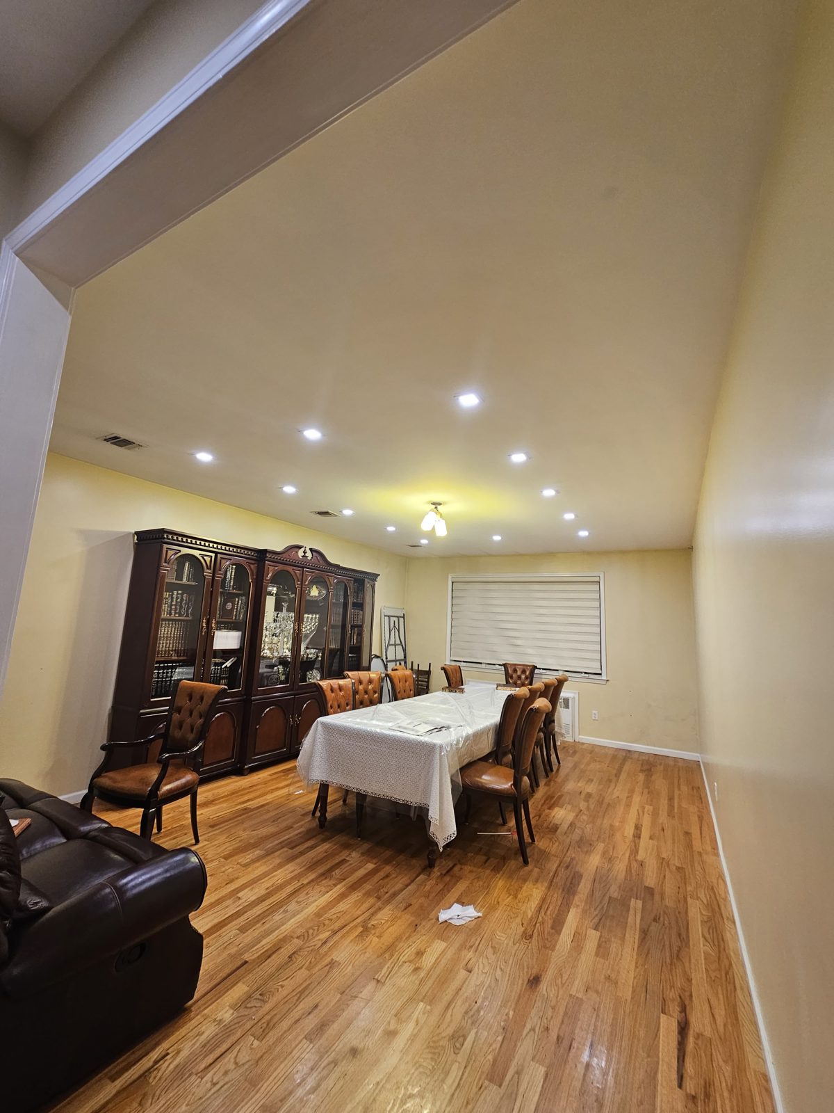 Set dining table on hardwood floors lit by recessed downlights