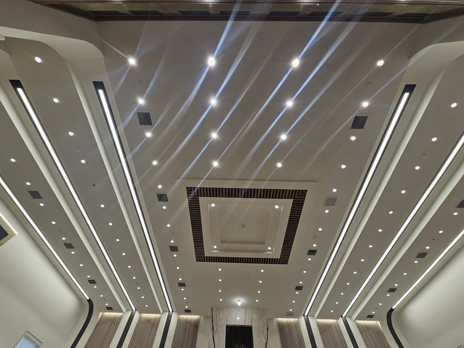 Dramatic ceiling with linear LED strips radiating around a central panel