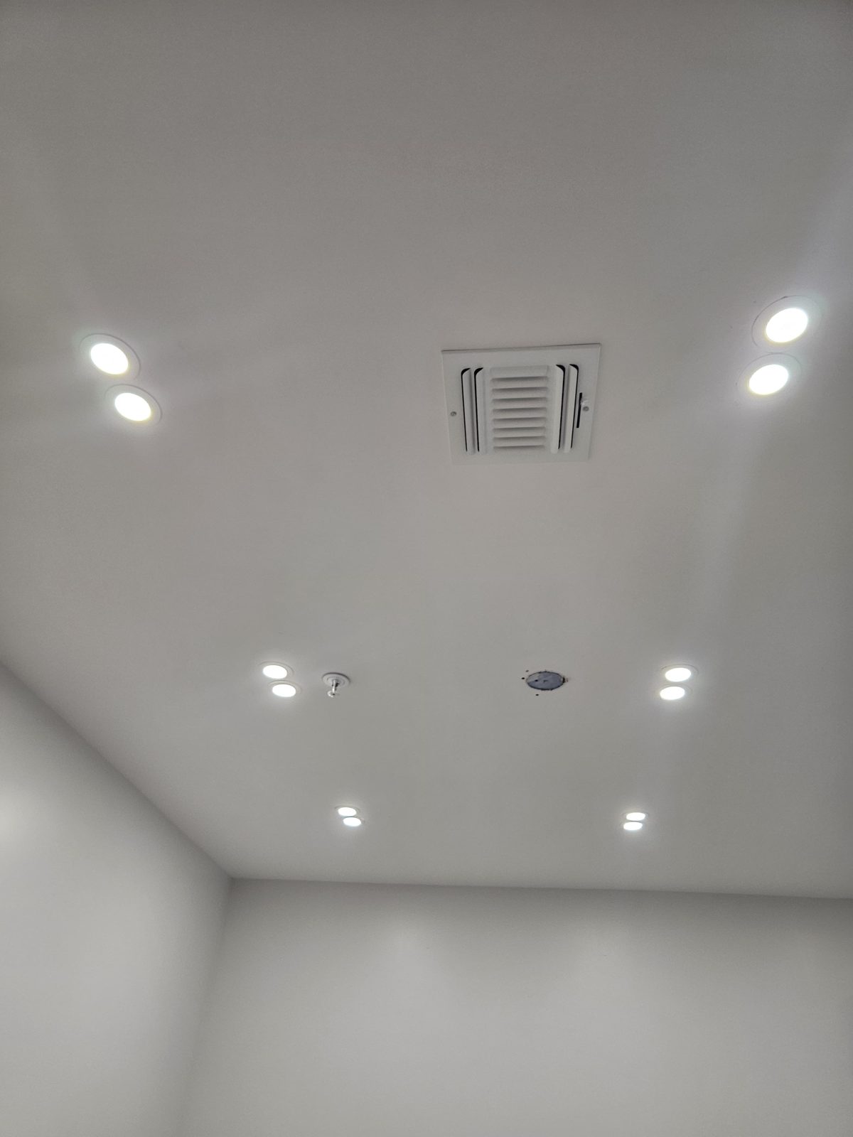 Close view of recessed downlights set into a smooth white ceiling