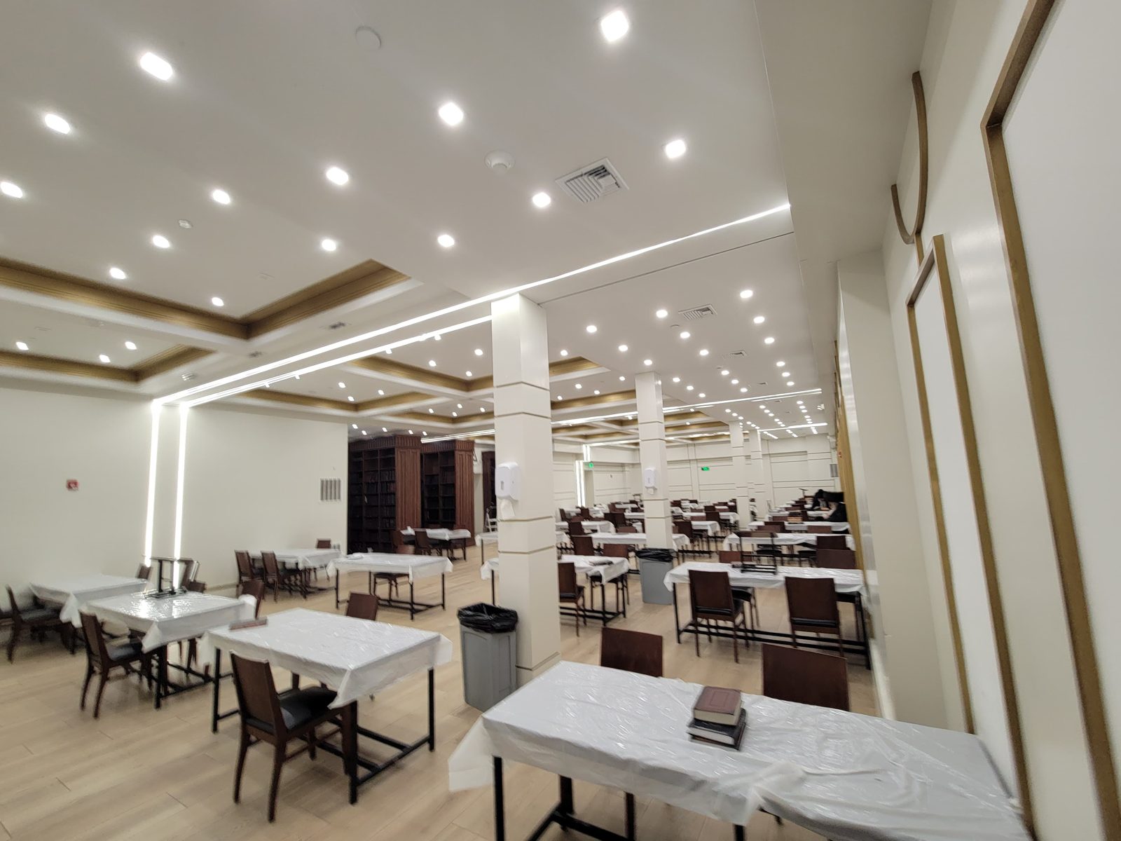 Banquet hall with long tables under continuous linear LED ceiling lines