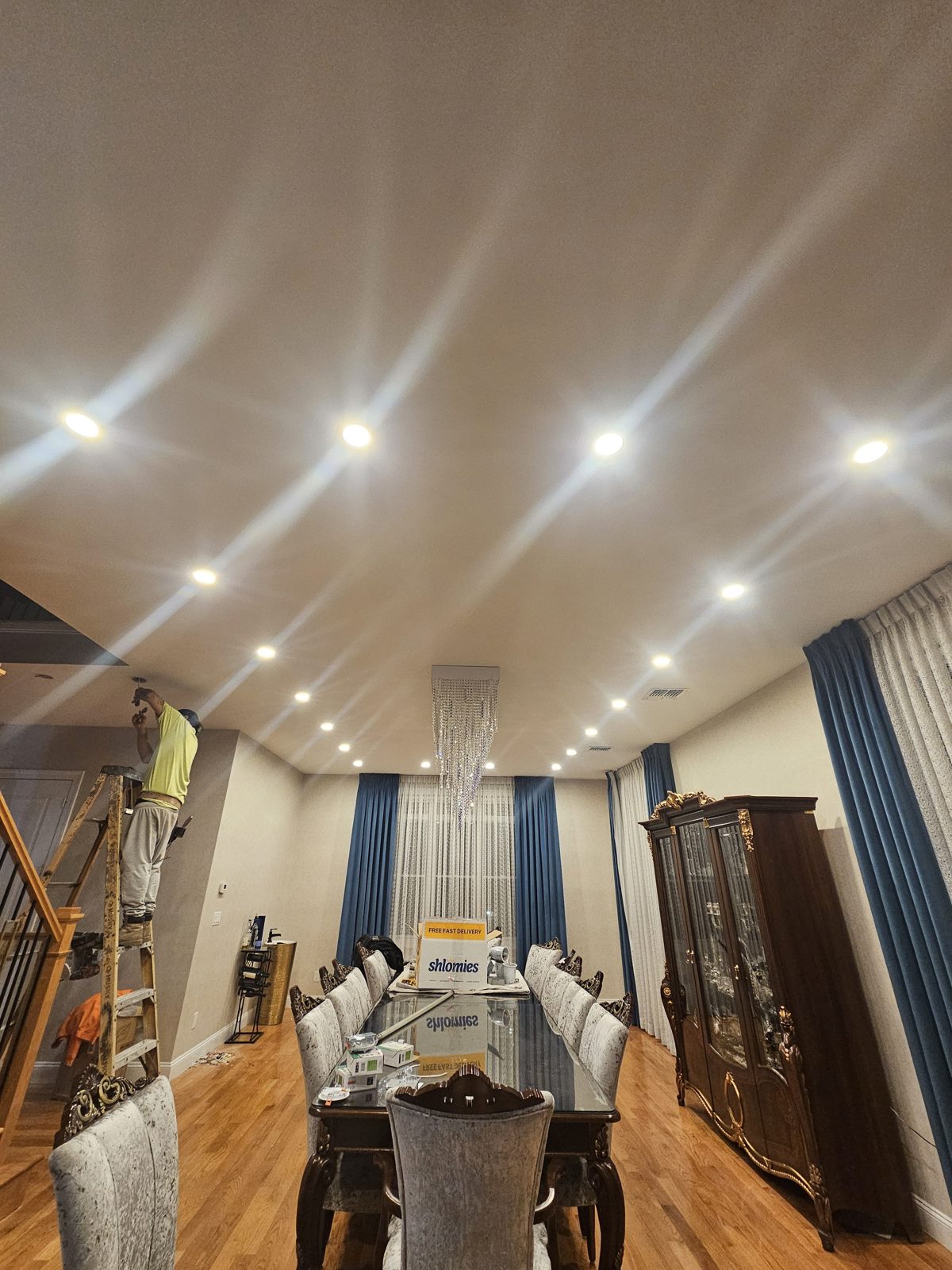 Dining room with tall drapes lit by recessed ceiling downlights