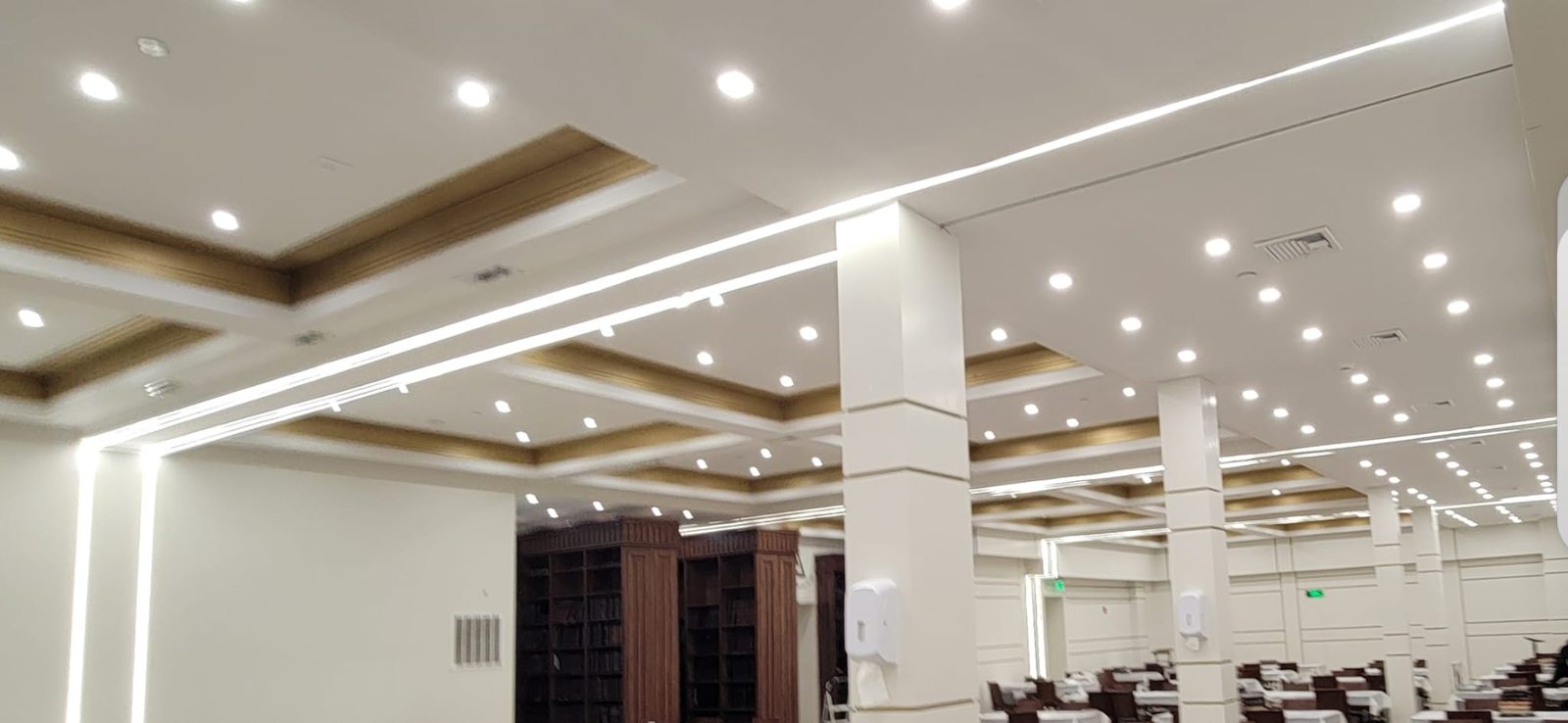 Coffered banquet ceiling combining linear LED light lines with recessed downlights