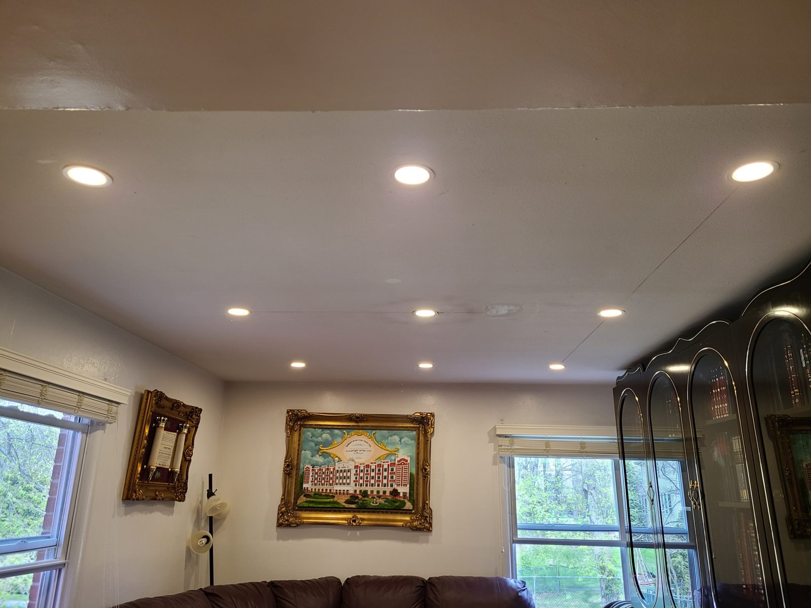 Living room with artwork lit by warm recessed downlights