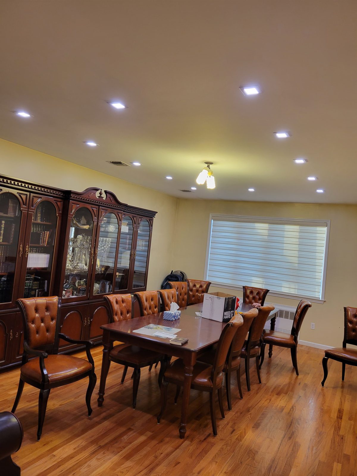 Formal dining room with a wooden table and recessed ceiling lighting